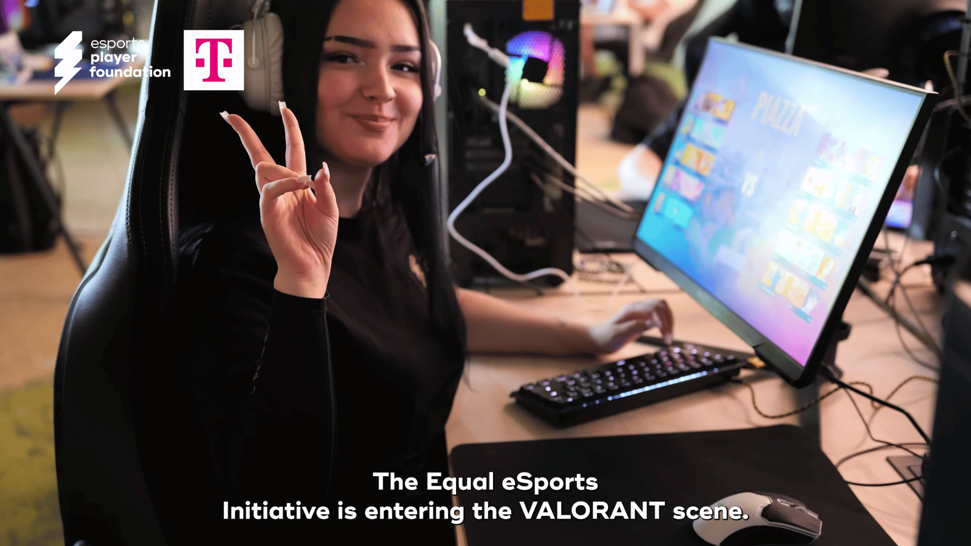 Eine Spielerin der Equal eSports Valorant Förderung spielt Valorat an einem PC oberhalb ihres Kopfes links sieht man die Logos der Telekom und der esports player foundation, welche Valorant unterstützen.