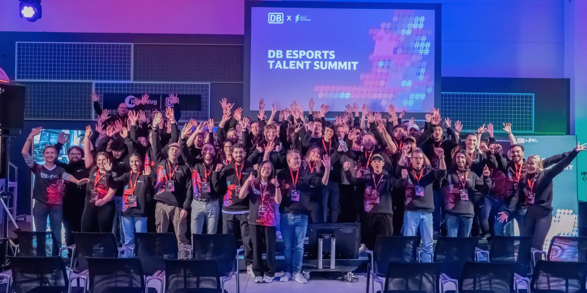 DB Esports-Stipendium Spieler bei DB Esports Summit DB Esports-Stipendium Spieler in DB Esports Trikots beim DB Esports Summit im DB Frankfurt Ideenzug Zentrum. Die Gruppe von jungen Talenten steht zusammen und lächelt vor einer modernen, innovativen Hintergrundkulisse, die den Summit und das Zentrum symbolisiert.