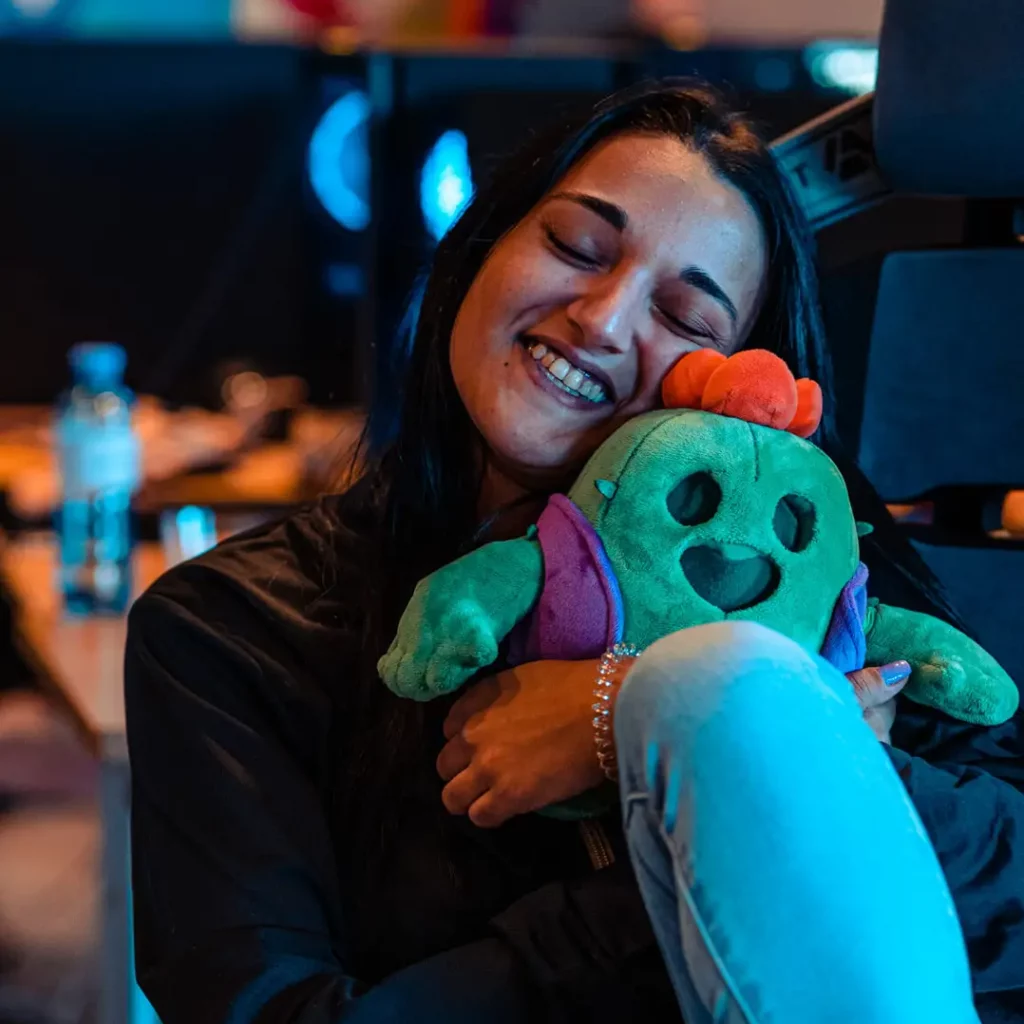 Brawl Stars Elternguide - ein Mädchen lächelt und hält ein Plüschtier in den Händen umschlungen. Das Plüschtier ist ein Charakter aus Brawl Stars namens Spike